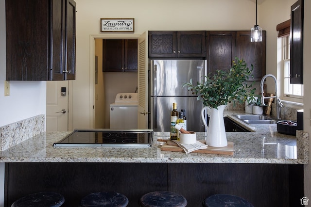 874 W Schneitter Cir Unit 7, Midway, UT 84049 - kitchen with freestanding refrigerator, washer / dryer, dark brown cabinets, a sink, and a peninsula