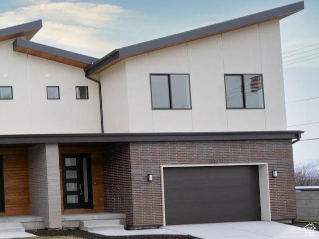 1782 E Bermondsey Ct, Holladay, UT 84117 - contemporary home with brick siding, a garage, stucco siding, and concrete driveway