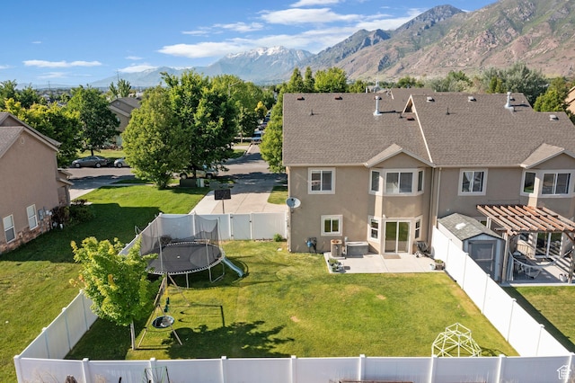 1099 W 200 S, Springville, UT 84663 - back of house with a trampoline, a patio, stucco siding, roof with shingles, and a mountain view