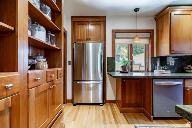 1376 E Perry Ave, Salt Lake City, UT 84103 - kitchen with stainless steel appliances, light wood-style flooring, decorative backsplash, and brown cabinets