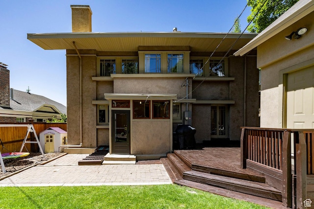 1376 E Perry Ave, Salt Lake City, UT 84103 - rear view of property with stucco siding, a chimney, and a wooden deck