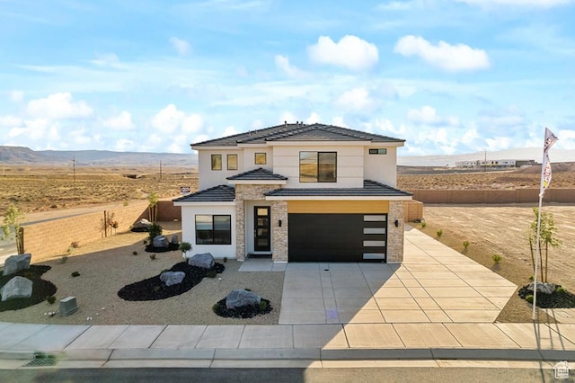 6068 S White Trails Dr, St George, UT 84790 - contemporary home featuring an attached garage, concrete driveway, stone siding, stucco siding, and a mountain view