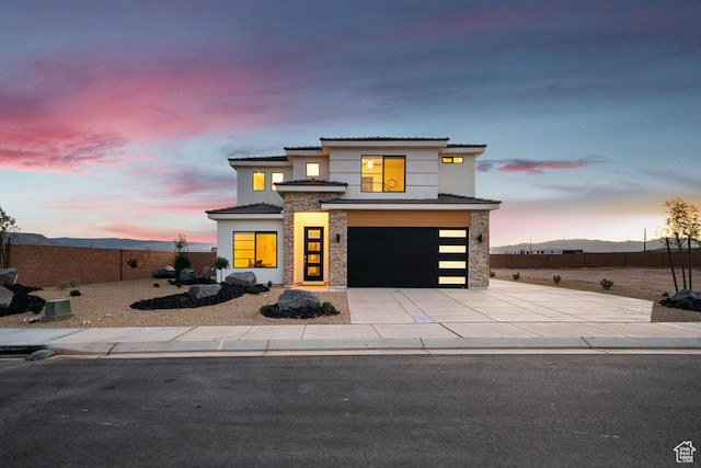 6068 S White Trails Dr, St George, UT 84790 - view of front of house featuring stone siding, a garage, driveway, and stucco siding