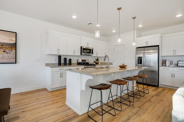 6068 S White Trails Dr, St George, UT 84790 - kitchen with stainless steel appliances, light wood-type flooring, a sink, a breakfast bar, and recessed lighting