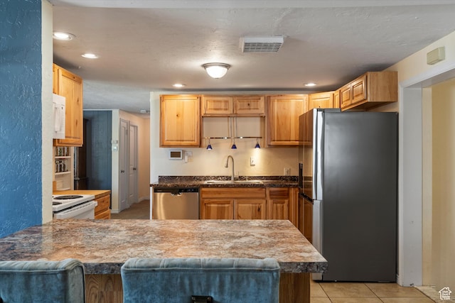 1225 E 5th St, Ogden, UT 84404 - kitchen with stainless steel appliances, a sink, a peninsula, light tile patterned floors, and recessed lighting