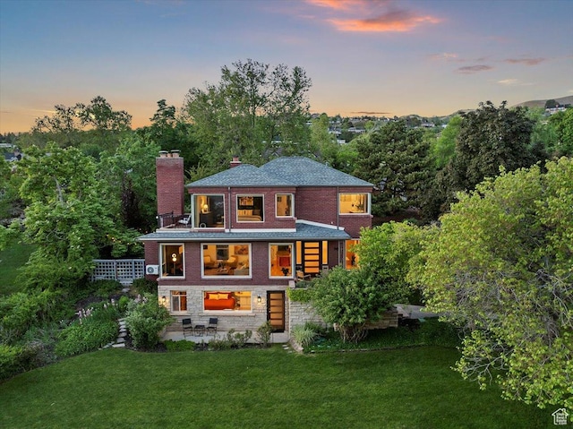 785 E Tenth Ave N, Salt Lake City, UT 84103 - back of house featuring a chimney, a lawn, brick siding, and a patio area