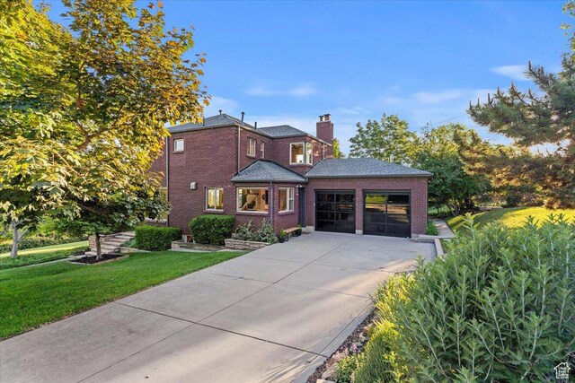 785 E Tenth Ave N, Salt Lake City, UT 84103 - view of front of property featuring a front lawn, a chimney, brick siding, driveway, and an attached garage