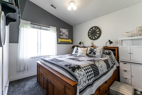 4732 W Wagon Train Dr, Herriman, UT 84096 - bedroom with vaulted ceiling, dark colored carpet, fridge, and wainscoting