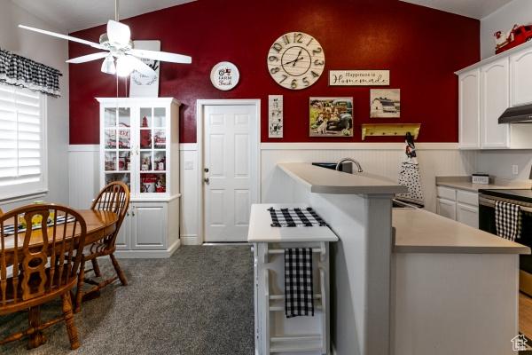 4732 W Wagon Train Dr, Herriman, UT 84096 - kitchen featuring vaulted ceiling, ceiling fan, light countertops, white cabinets, and range