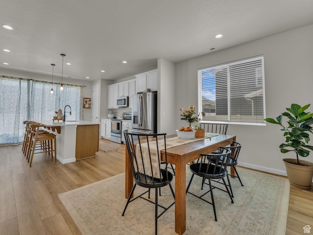 6352 N Canter Dr, Stansbury Park, UT 84074 - dining room with recessed lighting, light wood finished floors, and baseboards