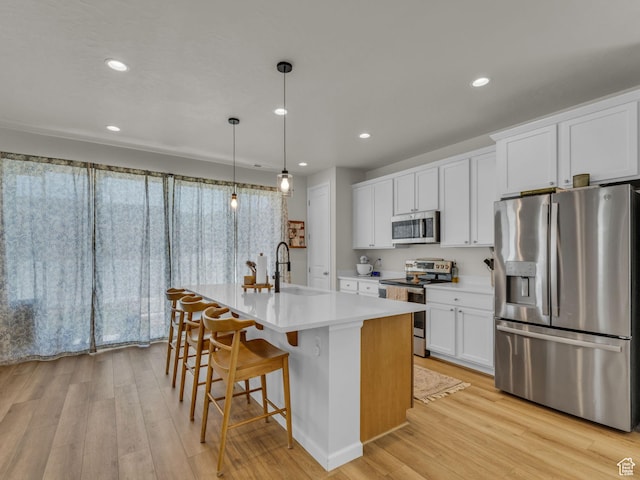 6352 N Canter Dr, Stansbury Park, UT 84074 - kitchen with stainless steel appliances, a sink, light wood finished floors, light countertops, and recessed lighting