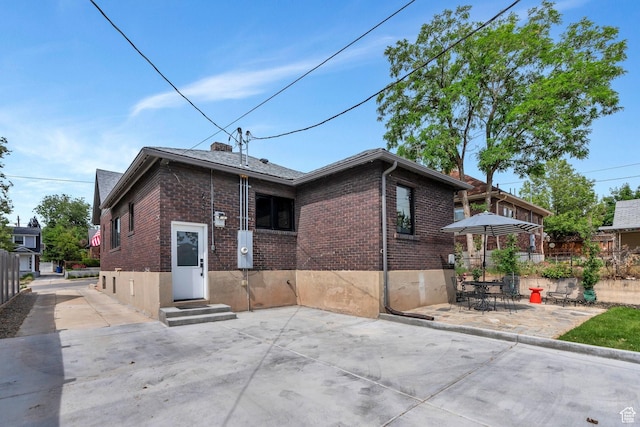 1440 E 1300 S, Salt Lake City, UT 84105 - rear view of house featuring entry steps, brick siding, and a patio area
