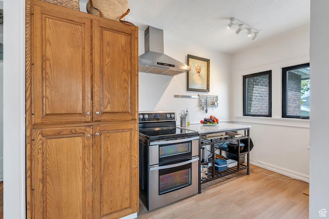 1440 E 1300 S, Salt Lake City, UT 84105 - kitchen with double oven range, wall chimney exhaust hood, light wood-style floors, and brown cabinetry