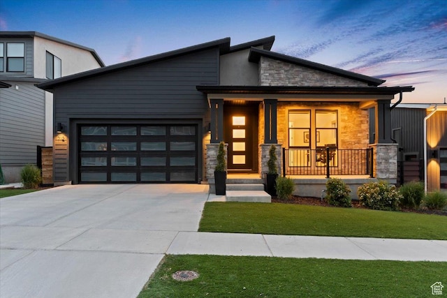 712 S Miller Ave, North Salt Lake, UT 84054 - contemporary home featuring stone siding, driveway, a garage, covered porch, and a front lawn