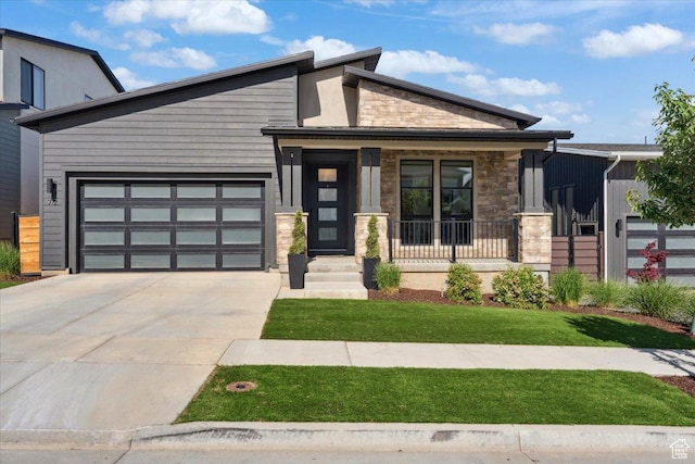 712 S Miller Ave, North Salt Lake, UT 84054 - view of front of house with stone siding, driveway, an attached garage, covered porch, and a front lawn