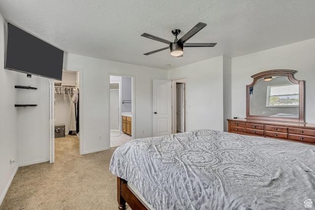 1254 W 2700 S, Syracuse, UT 84075 - bedroom featuring a walk in closet, light colored carpet, baseboards, a textured ceiling, and ensuite bath