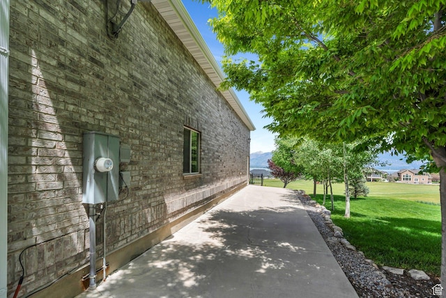 1736 S Range Rd, Saratoga Springs, UT 84045 - view of property exterior with a lawn, a patio, and brick siding
