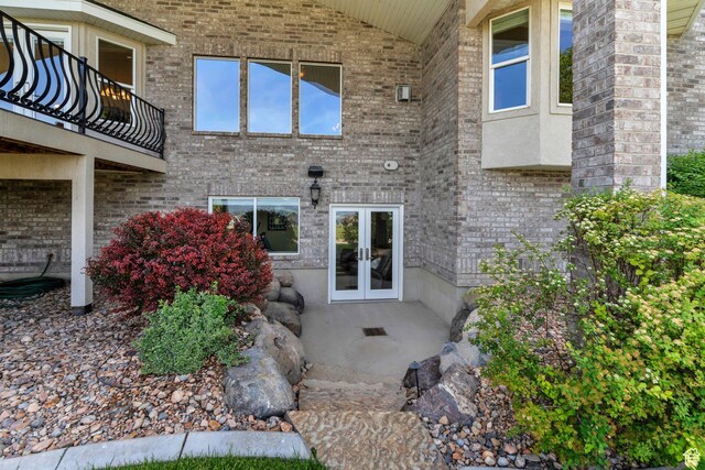1736 S Range Rd, Saratoga Springs, UT 84045 - view of exterior entry featuring french doors, a balcony, and brick siding