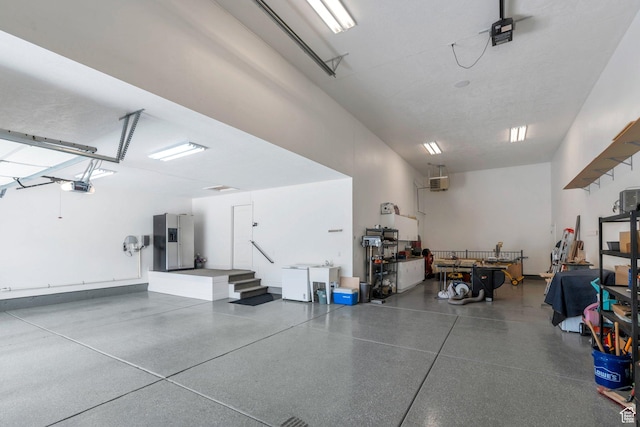 1736 S Range Rd, Saratoga Springs, UT 84045 - garage featuring a garage door opener and stainless steel fridge