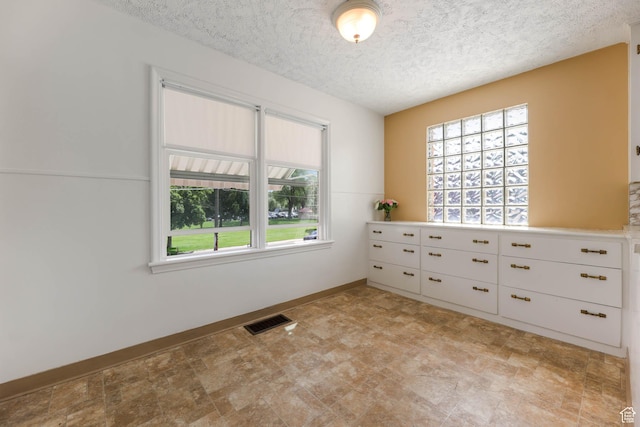 810 Canyon Rd, Ogden, UT 84404 - unfurnished room featuring plenty of natural light, a textured ceiling, and baseboards