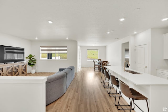 7405 W Glowing Sky Dr S, West Valley City, UT 84081 - living area with recessed lighting, healthy amount of natural light, light wood-type flooring, and baseboards