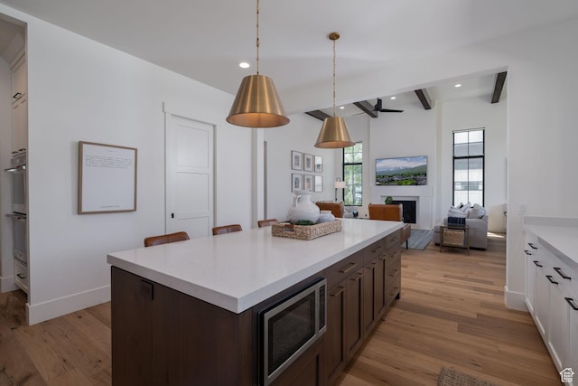517 N Farm Hill Ln, Midway, UT 84049 - kitchen featuring stainless steel microwave, light wood-style flooring, light countertops, recessed lighting, and dark brown cabinetry