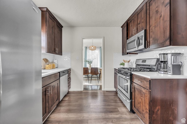 326 E 39th S, South Ogden, UT 84405 - kitchen with stainless steel appliances, light countertops, dark wood-style flooring, dark brown cabinets, and a textured ceiling
