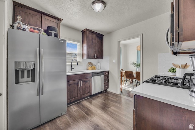 326 E 39th S, South Ogden, UT 84405 - kitchen with appliances with stainless steel finishes, a sink, dark wood finished floors, light countertops, and a textured ceiling