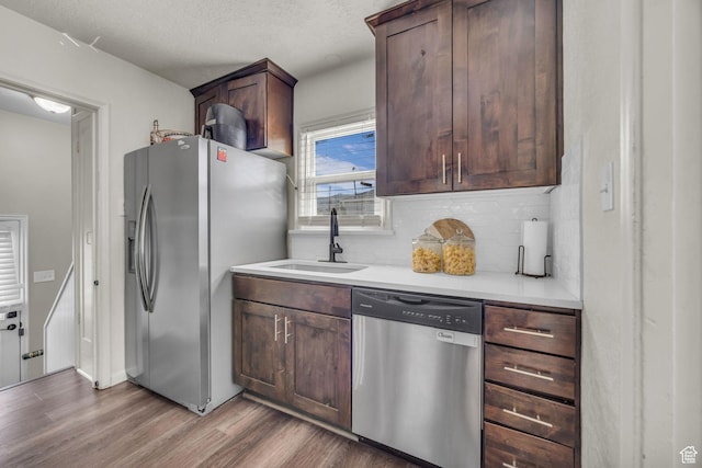 326 E 39th S, South Ogden, UT 84405 - kitchen featuring appliances with stainless steel finishes, a sink, wood finished floors, decorative backsplash, and light countertops