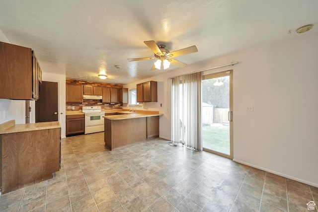 5373 S Clover Meadow Dr W, Murray, UT 84123 - kitchen with electric stove, a peninsula, a sink, under cabinet range hood, and light countertops