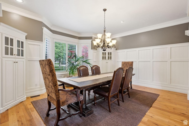 870 E Quail Hollow Cir, Alpine, UT 84004 - dining space with a decorative wall, a chandelier, light wood finished floors, crown molding, and wainscoting