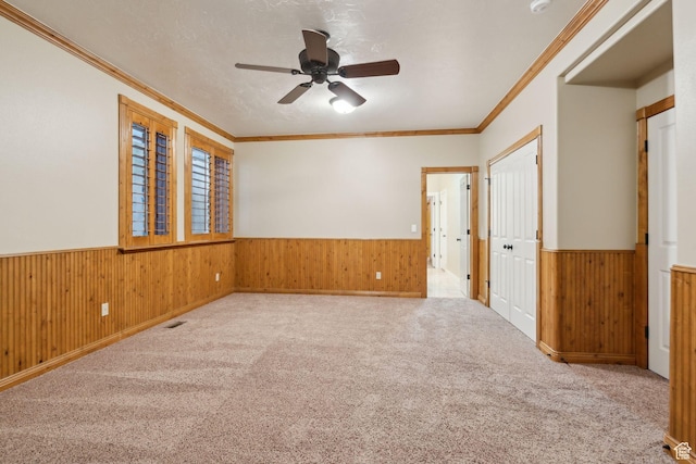 870 E Quail Hollow Cir, Alpine, UT 84004 - empty room with a wainscoted wall, ceiling fan, wooden walls, crown molding, and carpet flooring