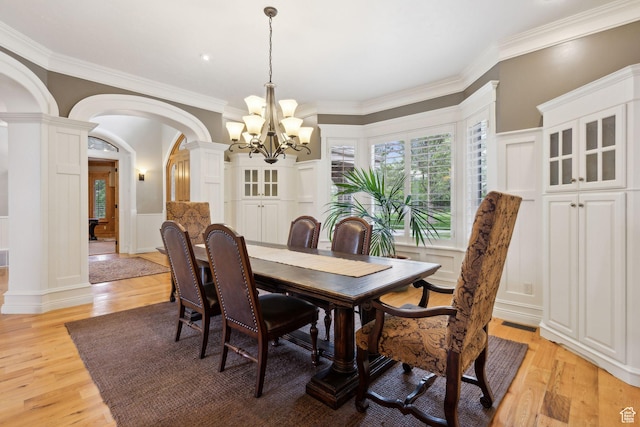 870 E Quail Hollow Cir, Alpine, UT 84004 - dining area with arched walkways, decorative columns, a decorative wall, a chandelier, and light wood-style flooring