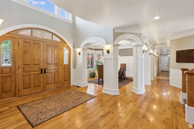 870 E Quail Hollow Cir, Alpine, UT 84004 - foyer with decorative columns, arched walkways, light wood-style flooring, a wainscoted wall, and a decorative wall
