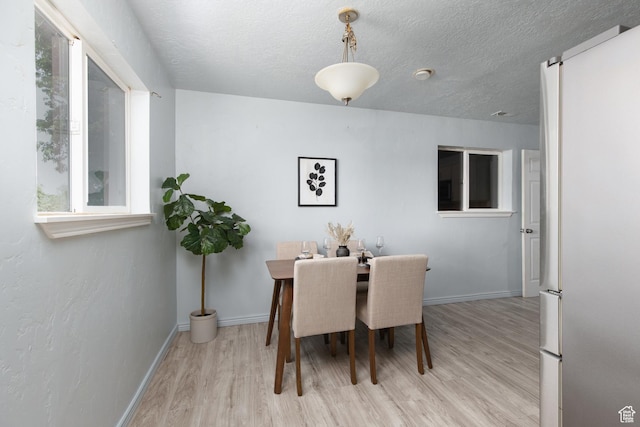 4815 W 4895 S, Kearns, UT 84118 - dining area with light wood-style floors, baseboards, and a textured ceiling