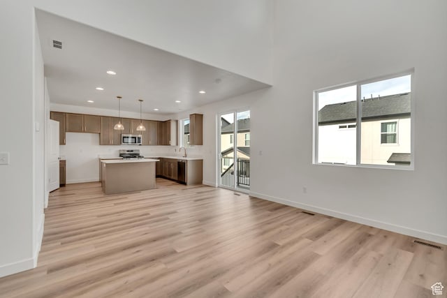 6737 S Glade Creek Dr W Unit 226, West Jordan, UT 84081 - kitchen with appliances with stainless steel finishes, light wood-style floors, light countertops, recessed lighting, and a kitchen island
