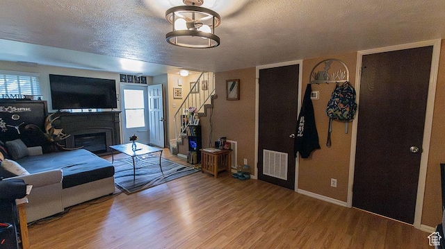 966 Mckinley Ave Unit B, Pocatello, ID 83201 - living room with stairway, light wood-style floors, a textured ceiling, and a fireplace with flush hearth