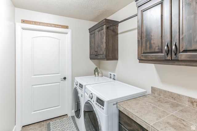 533 N Creek Ridge Cir, Washington, UT 84780 - washroom featuring cabinet space, independent washer and dryer, light tile patterned floors, and a textured ceiling