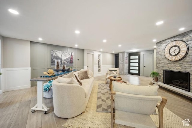 2341 E Neffs Ln S, Millcreek, UT 84109 - living room with a decorative wall, light wood-type flooring, recessed lighting, a fireplace, and wainscoting