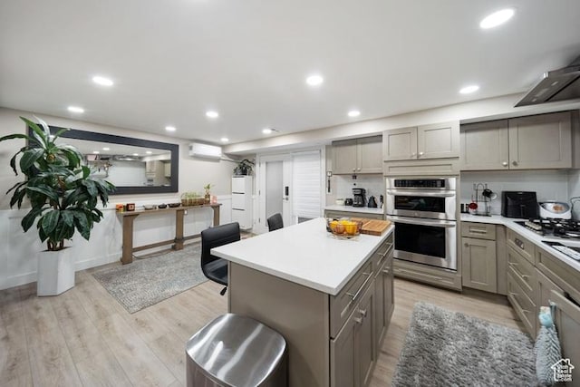 2341 E Neffs Ln S, Millcreek, UT 84109 - kitchen featuring gray cabinets, stainless steel appliances, a wall mounted AC, light countertops, and light wood-type flooring
