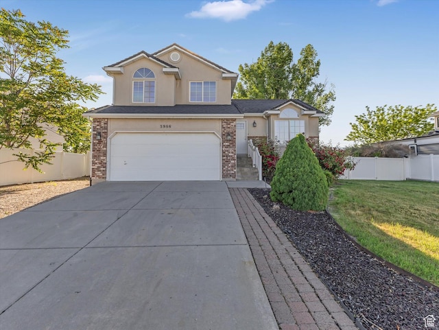 5986 S 4250 W, Roy, UT 84067 - view of front facade with stucco siding, an attached garage, concrete driveway, and brick siding