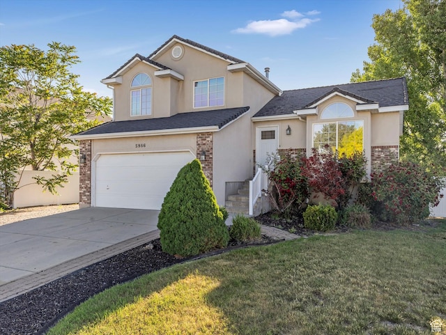 5986 S 4250 W, Roy, UT 84067 - traditional-style house featuring stucco siding, a garage, concrete driveway, and a front lawn