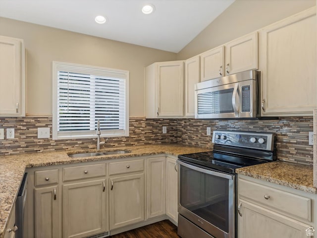 5986 S 4250 W, Roy, UT 84067 - kitchen featuring stainless steel appliances, a sink, vaulted ceiling, tasteful backsplash, and light stone counters