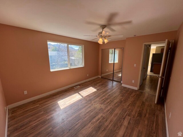 3722 S 8235 W, Magna, UT 84044 - unfurnished bedroom with dark wood-style floors, baseboards, a closet, and a ceiling fan