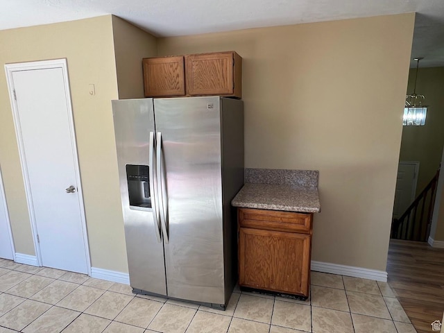 3722 S 8235 W, Magna, UT 84044 - kitchen with stainless steel fridge with ice dispenser, light tile patterned floors, brown cabinets, and baseboards