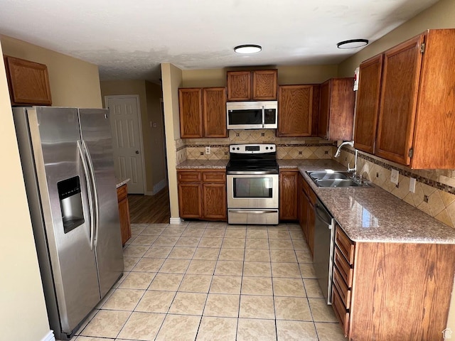 3722 S 8235 W, Magna, UT 84044 - kitchen featuring stainless steel appliances, a sink, brown cabinets, and tasteful backsplash