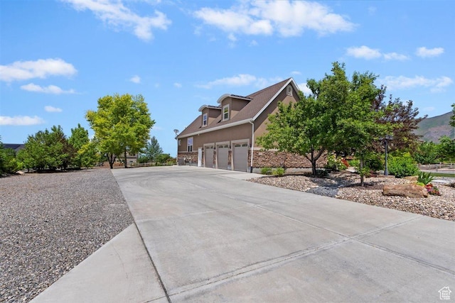 1097 E Highline Rd, Lake Point, UT 84074 - view of side of property featuring driveway, an attached garage, and stucco siding