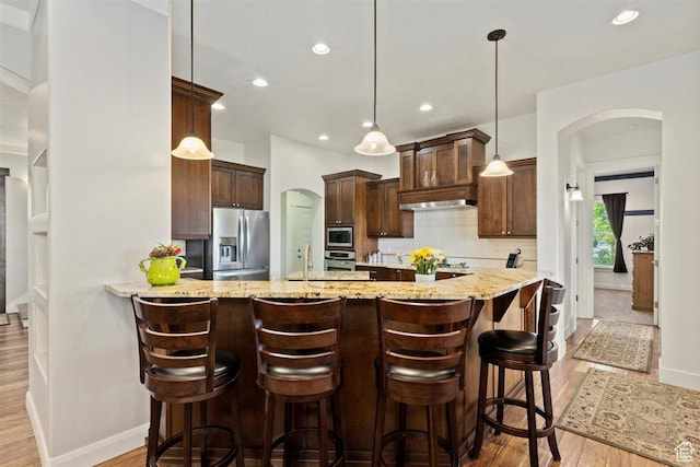 1097 E Highline Rd, Lake Point, UT 84074 - kitchen featuring appliances with stainless steel finishes, arched walkways, light wood-style floors, baseboards, and dark brown cabinets