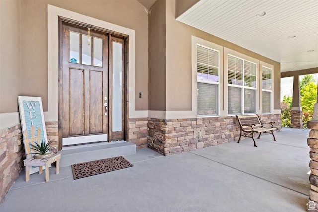 1097 E Highline Rd, Lake Point, UT 84074 - view of exterior entry with a porch, stone siding, and stucco siding