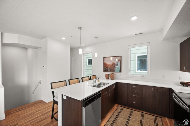 1034 W 1700 S Unit 121, Salt Lake City, UT 84104 - kitchen with stainless steel dishwasher, a sink, range, wood finished floors, and a breakfast bar